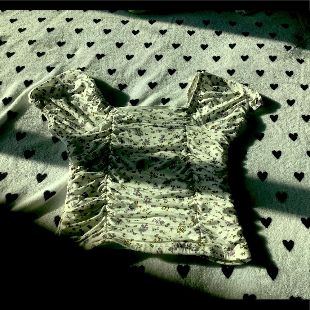 Shirt with ruffled indents and little flower designs.